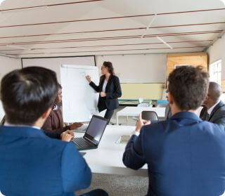 Businesswoman leading a training session with colleagues, highlighting the role of leadership in preventing workplace harassment.