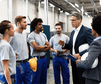 Supervisor explaining safety procedures to a team during a toolbox talk in an industrial facility.